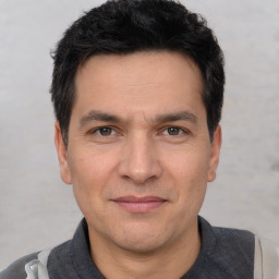 Joyful white adult male with short  black hair and brown eyes