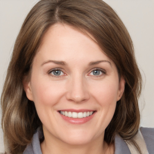 Joyful white young-adult female with medium  brown hair and grey eyes