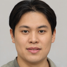 Joyful asian young-adult male with short  brown hair and brown eyes