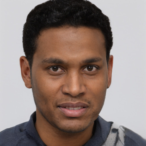 Joyful black young-adult male with short  brown hair and brown eyes