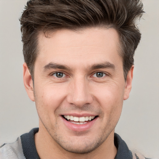 Joyful white young-adult male with short  brown hair and grey eyes