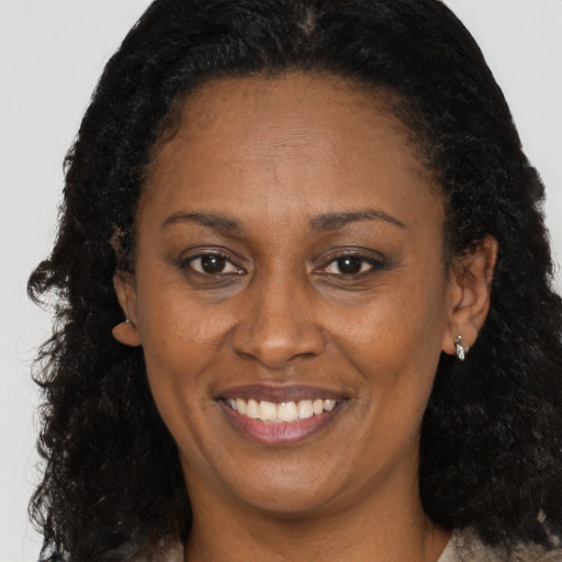 Joyful black adult female with long  brown hair and brown eyes