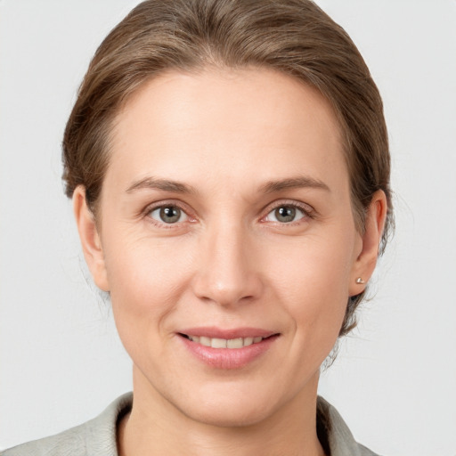 Joyful white young-adult female with medium  brown hair and grey eyes