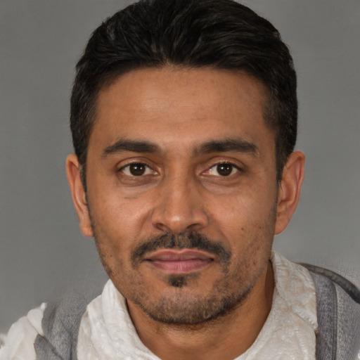 Joyful latino adult male with short  black hair and brown eyes