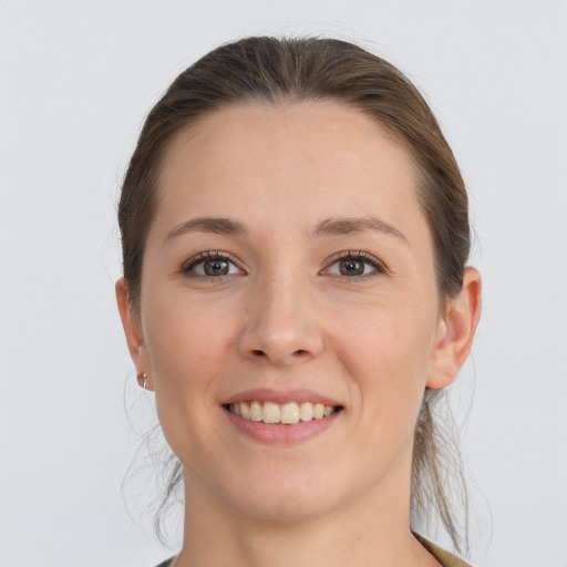 Joyful white young-adult female with long  brown hair and grey eyes