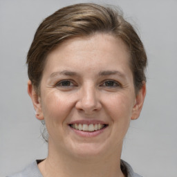 Joyful white young-adult female with short  brown hair and grey eyes