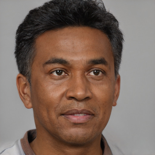 Joyful black adult male with short  black hair and brown eyes