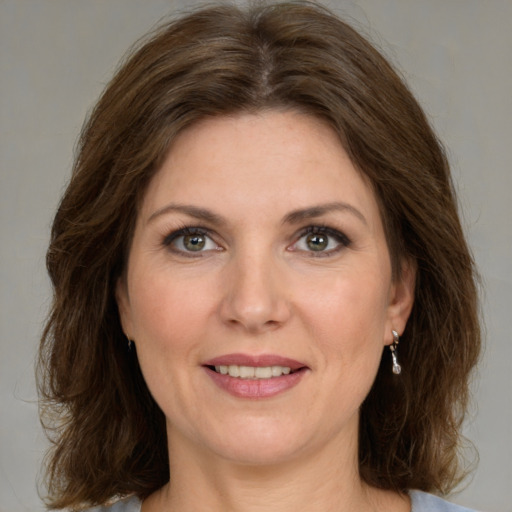 Joyful white adult female with medium  brown hair and green eyes