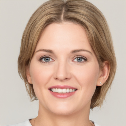 Joyful white young-adult female with medium  brown hair and grey eyes