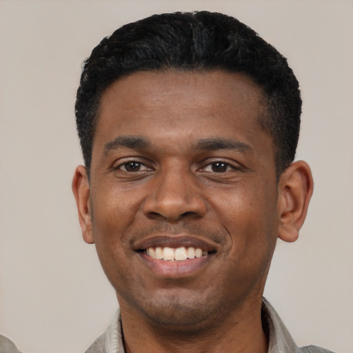 Joyful latino young-adult male with short  black hair and brown eyes