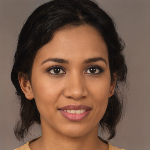 Joyful latino young-adult female with medium  brown hair and brown eyes