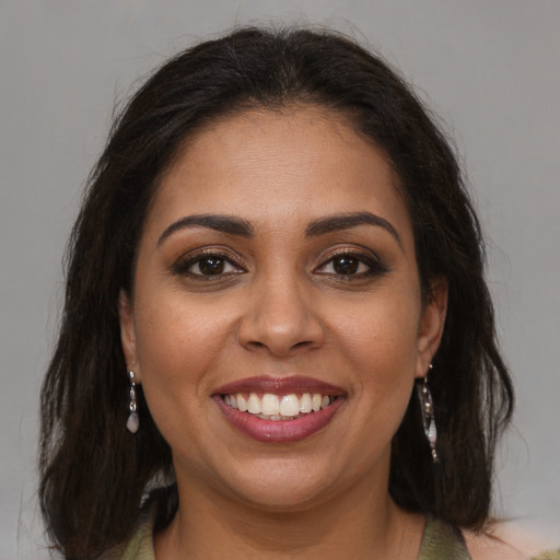 Joyful latino young-adult female with medium  brown hair and brown eyes