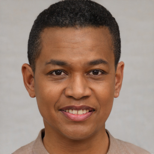 Joyful black young-adult male with short  black hair and brown eyes