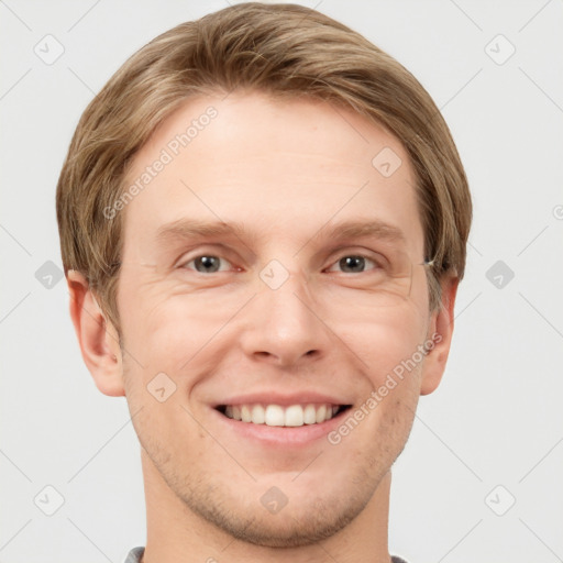 Joyful white young-adult male with short  brown hair and grey eyes