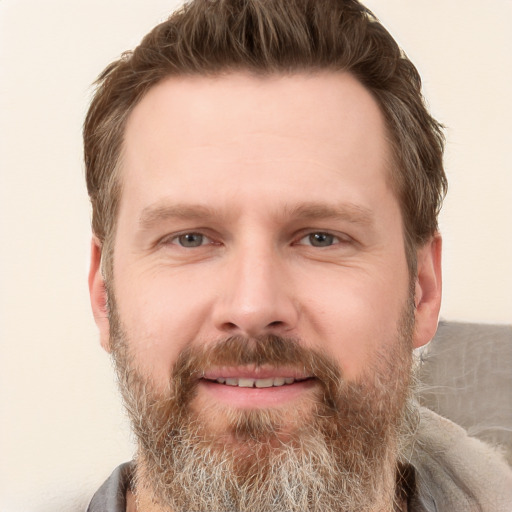 Joyful white adult male with short  brown hair and grey eyes