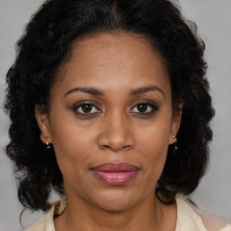 Joyful black adult female with medium  brown hair and brown eyes