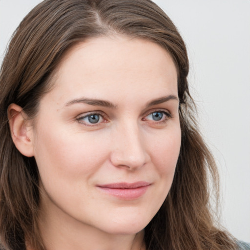 Joyful white young-adult female with long  brown hair and blue eyes