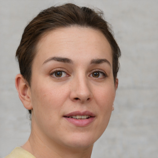 Joyful white young-adult female with short  brown hair and grey eyes