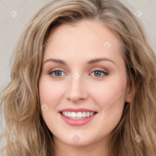 Joyful white young-adult female with long  brown hair and blue eyes