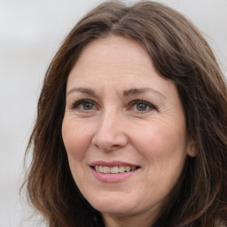 Joyful white adult female with long  brown hair and grey eyes