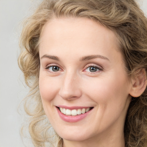 Joyful white young-adult female with medium  brown hair and blue eyes