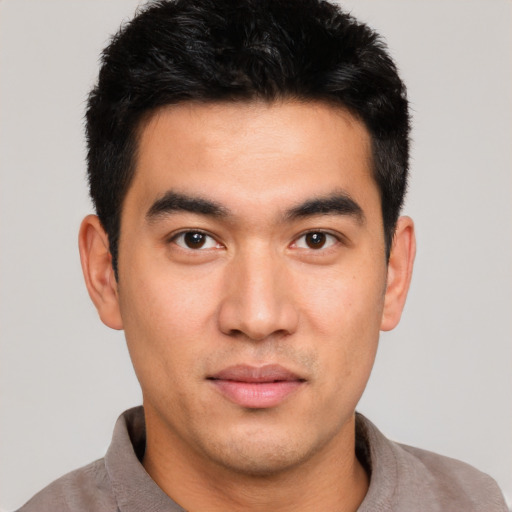 Joyful latino young-adult male with short  black hair and brown eyes