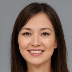 Joyful white young-adult female with long  brown hair and brown eyes