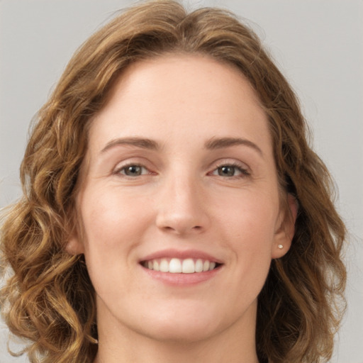 Joyful white young-adult female with long  brown hair and green eyes