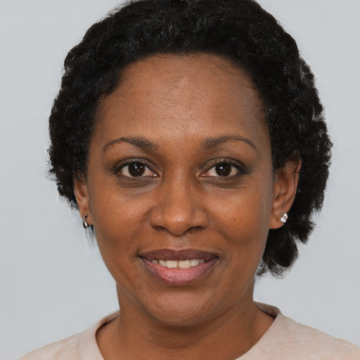 Joyful black adult female with short  black hair and brown eyes