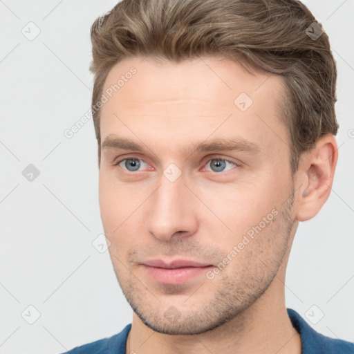 Joyful white young-adult male with short  brown hair and grey eyes