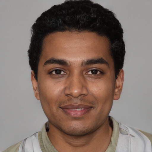 Joyful black young-adult male with short  black hair and brown eyes