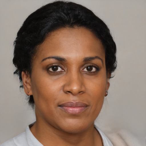 Joyful black adult female with short  black hair and brown eyes