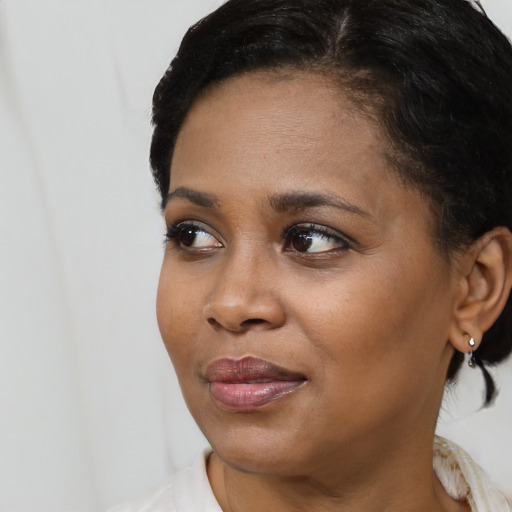 Joyful black young-adult female with medium  black hair and brown eyes