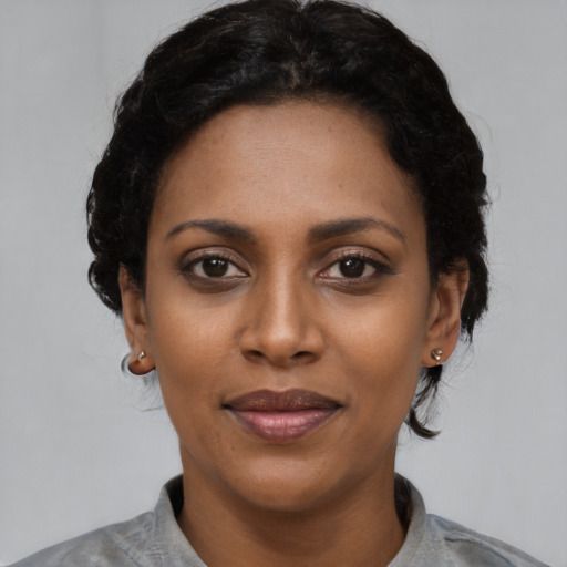 Joyful latino young-adult female with short  black hair and brown eyes