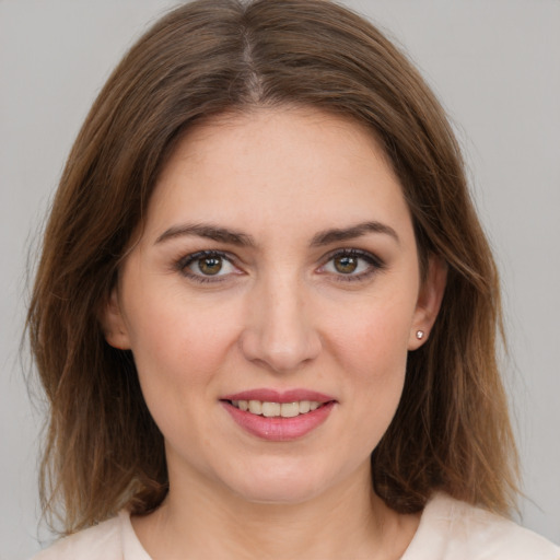 Joyful white young-adult female with medium  brown hair and green eyes