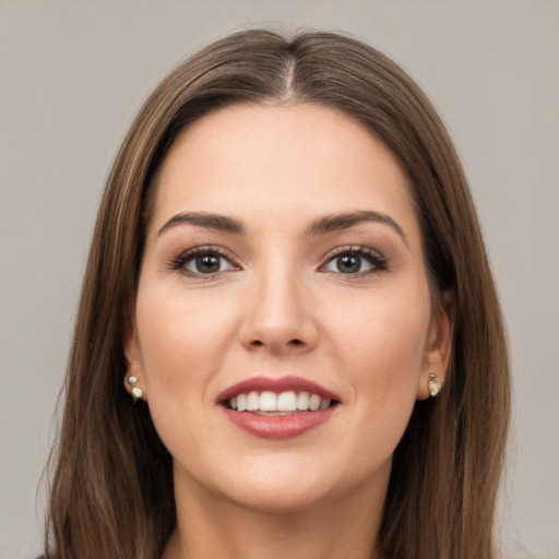 Joyful white young-adult female with long  brown hair and green eyes