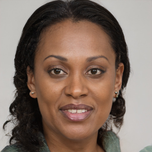 Joyful black adult female with medium  brown hair and brown eyes