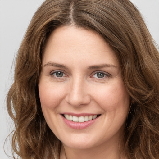 Joyful white young-adult female with long  brown hair and green eyes