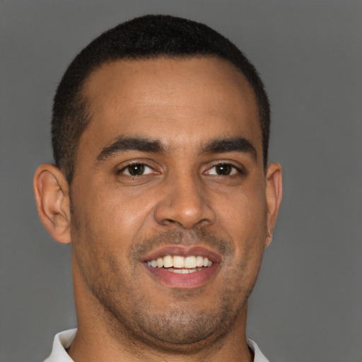 Joyful black young-adult male with short  brown hair and brown eyes