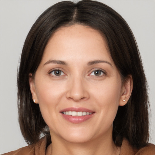 Joyful white adult female with long  brown hair and brown eyes