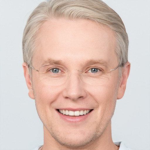 Joyful white adult male with short  brown hair and blue eyes