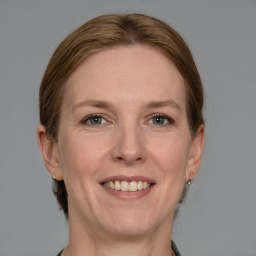 Joyful white adult female with medium  brown hair and grey eyes