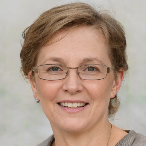 Joyful white middle-aged female with medium  brown hair and blue eyes