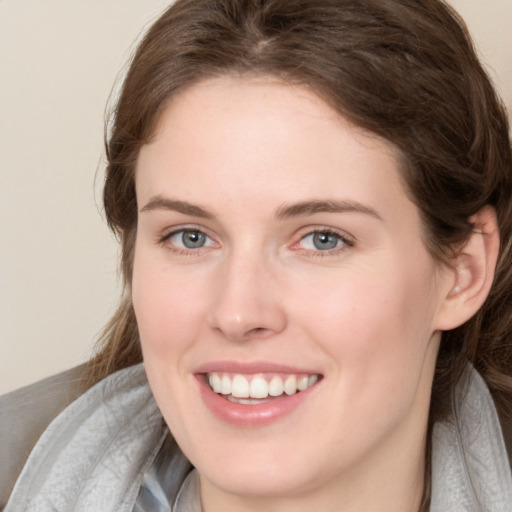 Joyful white young-adult female with medium  brown hair and blue eyes