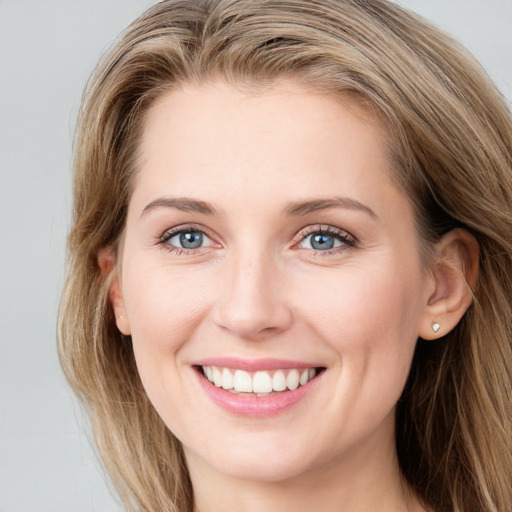 Joyful white young-adult female with long  brown hair and blue eyes