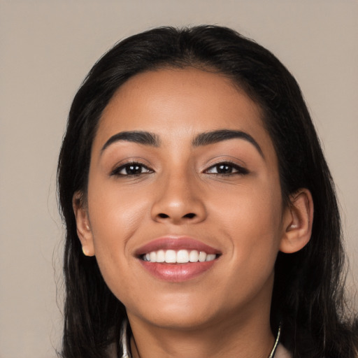 Joyful latino young-adult female with long  black hair and brown eyes