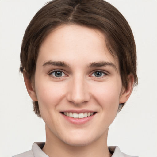 Joyful white young-adult female with short  brown hair and grey eyes