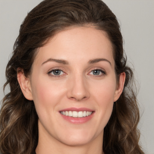 Joyful white young-adult female with long  brown hair and green eyes