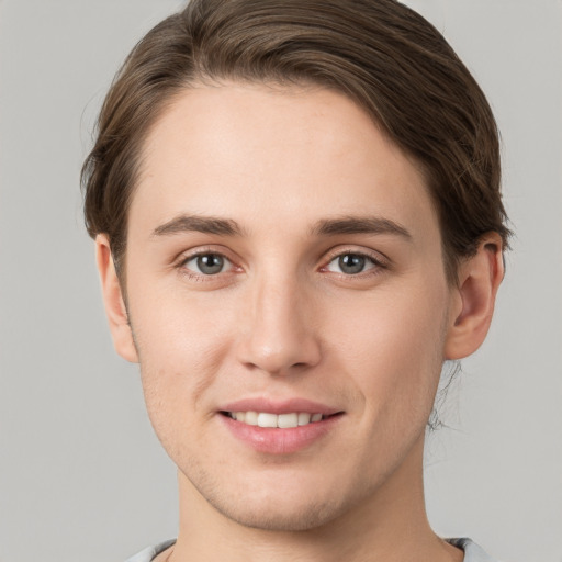 Joyful white young-adult male with short  brown hair and grey eyes