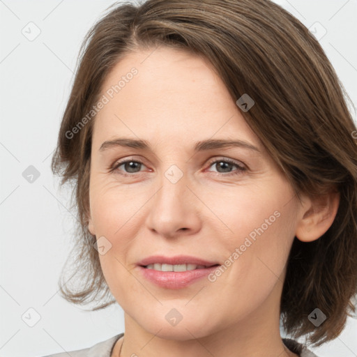 Joyful white adult female with medium  brown hair and grey eyes